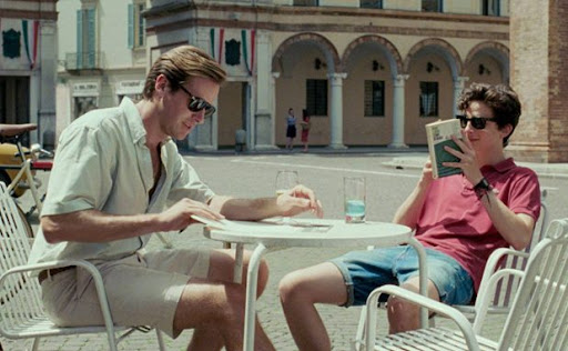 Actores de 'Call Me by Your Name' con un vestuario que combina polos, shorts y camisas abiertas en un ambiente idílico de verano.