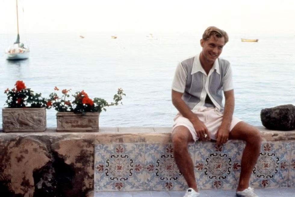 Personajes de 'El talento de Mr. Ripley' con vestuario de lino, camisas de polo y colores azul marino y blanco.